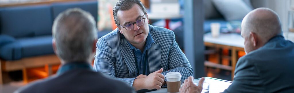 3 financial advisors having a discussion at a conference